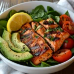 Fresh salmon salad with greens, avocado, and cherry tomatoes.